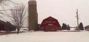 Photo of a red barn and silo in the snow