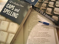 Caps and Spelling Book next to another book and a pen