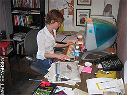 Woman at computer with papers on desk