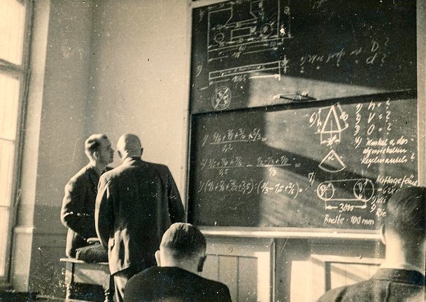 Two men looking at blackboard