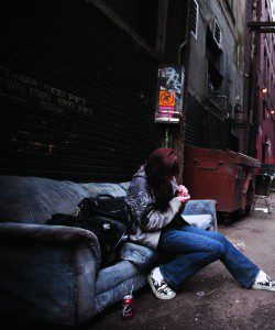 Woman on couch in alley