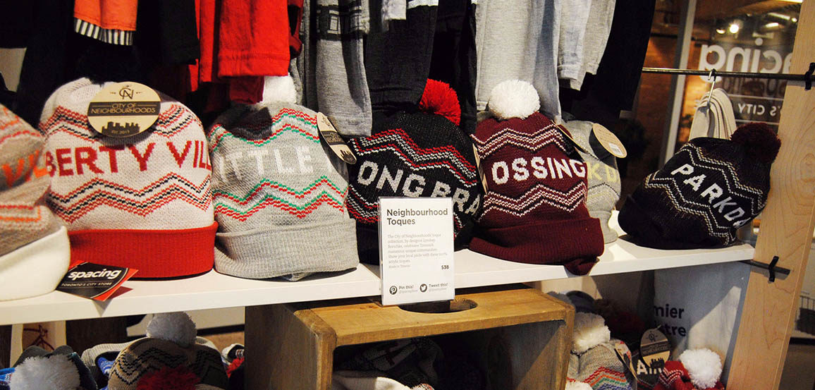 Toques printed with the names of Toronto neighbourhoods sit on a shelf at the Spacing Store in Toronto