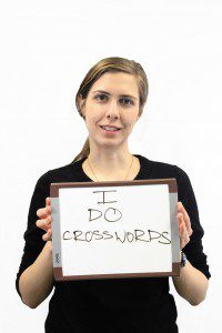 Woman holds whiteboard "I do crosswords"