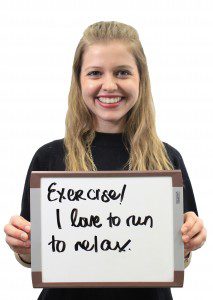 Woman holds whiteboard "Exercise! I love to run to relax"