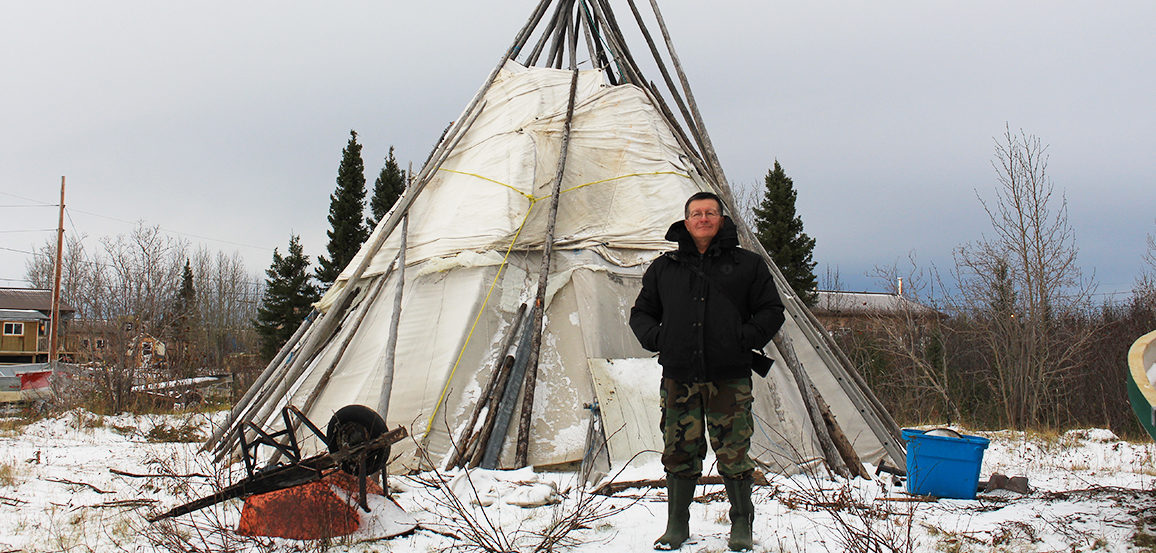 Man stands in front of teepee
