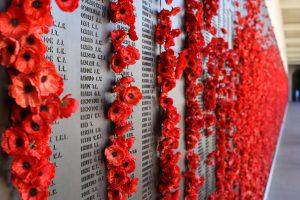 Memorial lists names of lost soldiers and it adorned with poppies