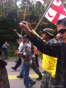 Indigenous people march, carrying flags