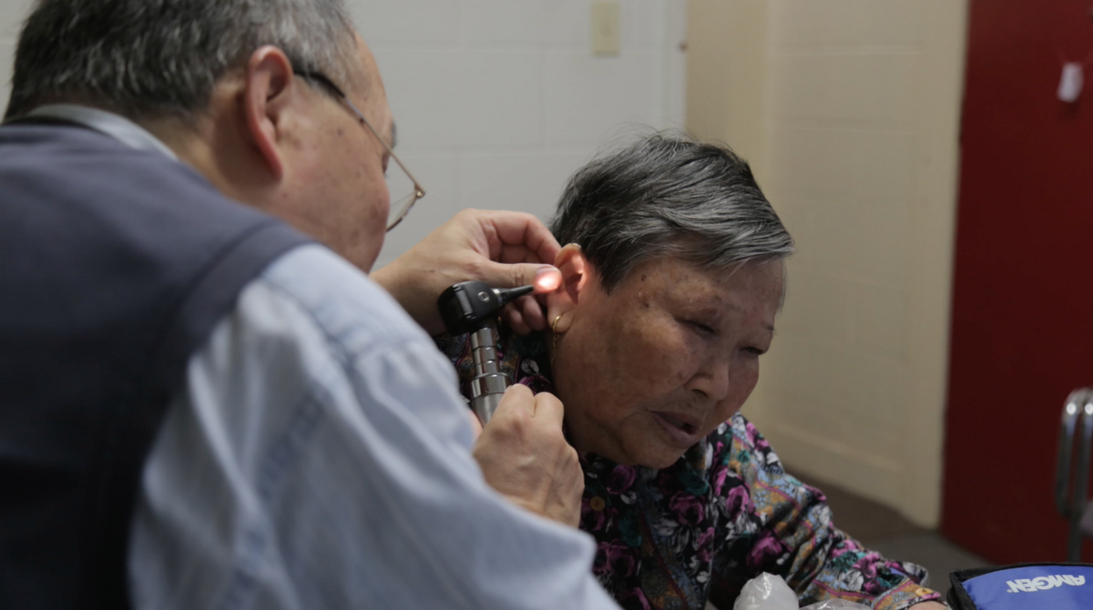 A doctor examines an elderly woman in Kensington-Chinatown (Photo: The Local)