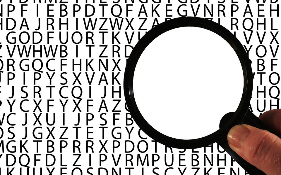 A magnifying glass looking at letters in the alphabet