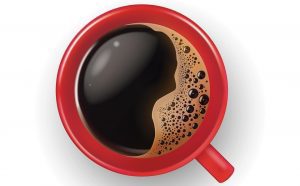 A cup of black coffee with foam at the top