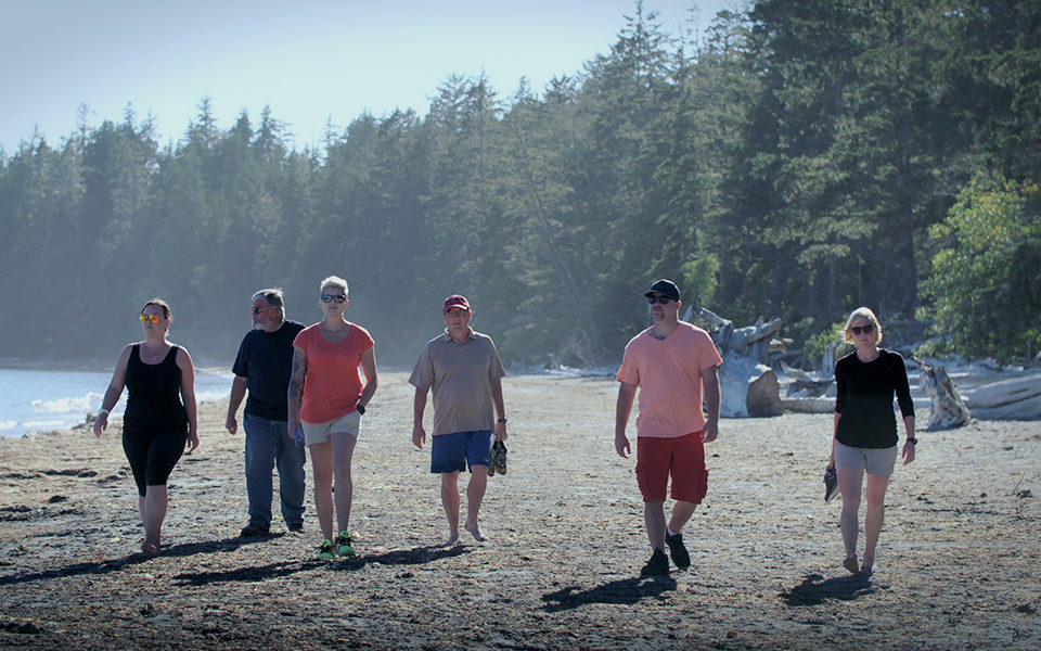 A group of people walk along a beach