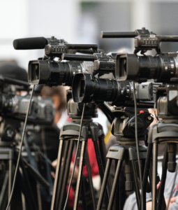 Multiple professional cameras on tripods aiming in the same direction