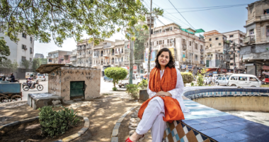 Sanam Maher sits on the ledge of an empty fountain in Pakistan